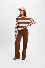 Jean de corte recto y tiro medio, color marrón, con cierre frontal de botón y cremallera, y bolsillos laterales y traseros.