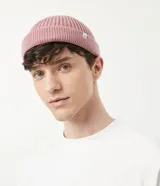 Gorro tipo fisherman de tejido acrílico con textura acanalada, diseño corto y etiqueta pequeña con logo en el frente.