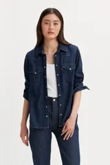 Camisa de denim azul con bolsillos en el pecho con solapas puntiagudas y cierre con broches a presión.