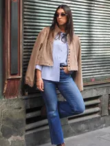 Campera bomber color beige, de corte oversize, con cuello redondo, cierre frontal de broches y mangas abullonadas.