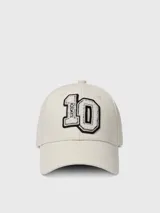 Gorra de béisbol color crema o blanco roto, con visera curva y parche frontal grande con el número "10" y la inscripción "10DAYS" en negro.