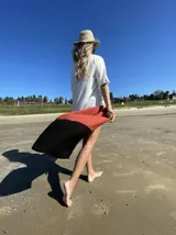 Vestido camisero largo de lino, con corte evasé, mangas cortas y diseño a bloques de color: blanco en la parte superior, terracota en el centro y negro en el ruedo.