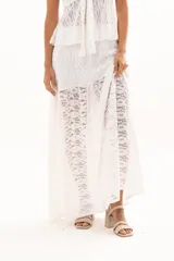 Pollera larga de encaje blanco con diseño de capas y transparencia, de corte fluido y estilo romántico.