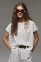Blusa de lino color blanco, con cuello bote y mangas cortas de corte holgado.
