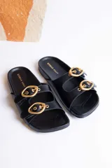 Sandalias negras con dos tiras anchas sobre el empeine, hebillas doradas ajustables y plantilla anatómica.