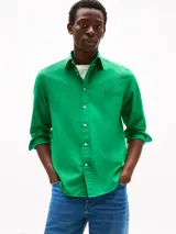 Camisa de popelina de algodón verde, con cuello abotonado, mangas largas con puños abotonados y logo de Tommy Hilfiger bordado en el pecho. Confeccionada con tecnología Flex para mayor comodidad.