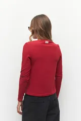 Remera negra de manga larga, cuello alto y corte diagonal en la parte inferior.