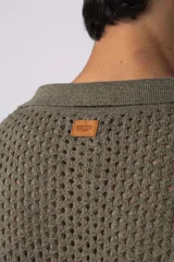 Camisa de manga corta tejida en algodón con diseño calado, cuello tipo bowling y cierre frontal con botones al tono.
