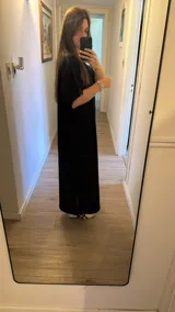 Vestido largo negro de morley de algodón, de corte holgado, mangas cortas y aberturas laterales en el bajo.