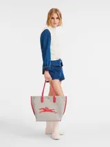 Bolso shopper Longchamp modelo Le Roseau Essential, tamaño L, color crudo con detalles en rojo y logo de jinete bordado.