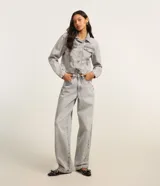 Pantalón de jean estilo baggy con corte holgado y recto, de tiro alto, con trabillas en la cintura, cierre tradicional y bolsillos laterales y traseros.