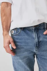 Pantalón de jean color celeste claro, de corte regular y estilo clásico.