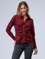 Camisa color borgoña en símil suede, marca Ninety. Cuello con solapa, abertura central con botones y delantera fruncida.