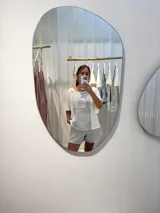 Remera blanca con detalles de puntilla y combinaciones de algodón y lino. Más corta adelante y un poco más larga atrás, con cortes laterales.