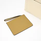 Cartera tipo tote de cuero sintético color beige con bolsillo frontal y correa bandolera ajustable y desmontable.