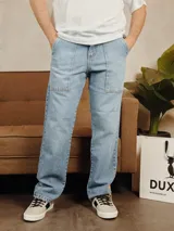 Pantalón de jean color celeste claro, de corte recto y estilo carpenter con bolsillos frontales aplicados.