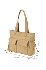 Cartera tipo shopper de poliuretano color beige, con dos bolsillos frontales con solapa, tirantes largos para el hombro y cordones ajustables en los laterales.