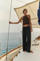 Pantalón tejido negro con rayas verticales color crema y marrón en los laterales y cintura elastizada.