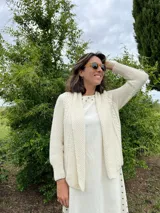 Cardigan tejido a mano color crudo, con solapa en el escote y punto delicado.