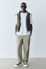 Remera blanca de corte holgado con cuello redondo ribeteado y hombros caídos. Confeccionada con tejido funcional COOLMAX®, una fibra de poliéster de secado rápido que elimina la humedad y regula la temperatura corporal.