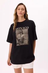 Remera negra de corte oversize con estampa fotográfica de una mujer fumando en Mónaco y texto con el nombre de la ciudad y Mont Carlo.