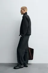 Cazadora de corte relajado confeccionada en tejido con estructura de espiga. Presenta cuello solapa, cierre frontal con cremallera, bolsillos de vivo en la cadera y bajo con pliegues en delantero y espalda.