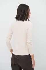 Polera de manga larga con cuello alto, confeccionada en tejido suave de viscosa con corte relajado y detalle de costura tipo collareta en la espalda.