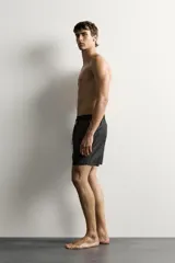 Short de baño negro de tejido técnico, con cintura elástica ajustable con cordón, bolsillos laterales y forro interior, perteneciente a la colección especial Aaron Levine x Zara.