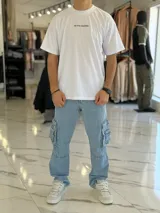 Pantalón cargo de jean estilo oversize, color celeste, con bolsillos laterales con solapa y corte recto.