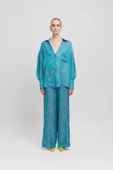 Maxi blusa celeste con estampado floral en tonos grises, mangas caídas, bolsillo de parche y corte oversize.