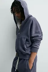 Sudadera de algodón con efecto lavado, color azul oscuro/gris pizarra, de corte 'boxy fit' y cierre frontal de cremallera. El interior de la capucha está forrado en tejido waffle de color gris claro. Posee bolsillos frontales de plastrón.