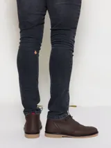 Botas tipo chukka de cuero color marrón, con cordones y suela de goma.