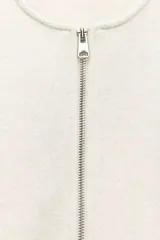 Chaqueta bomber de cuello redondo y manga larga con diseño holgado. Presenta cierre frontal con cremallera, bolsillos delanteros de vivo y acabados elásticos en los puños y el ruedo.