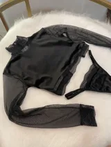 Conjunto de lencería compuesto por un top de cuello alto con mangas largas de microtul y detalles de encaje, y una tanga regulable de terciopelo y encaje.
