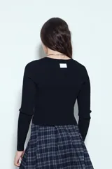 Top de tejido acanalado color negro, con escote en V y cierre frontal mediante cordones ajustables con ojales metálicos. Presenta mangas largas y un corte entallado al cuerpo.