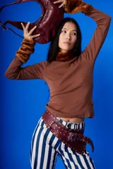 Cinto faja de cuero color bordó con tachas plateadas y hebilla metálica.