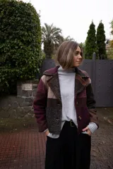 Chaquetón corto de lana con diseño de cuadros en tonos tierra y borravino, con solapas amplias y cierre frontal de botones.