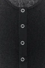 Top sin mangas de tejido de punto acanalado, color negro, con cuello redondo y cierre frontal de botones pequeños.