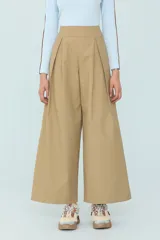 Pantalón color beige de corte amplio con pinzas al frente y bolsillos traseros.