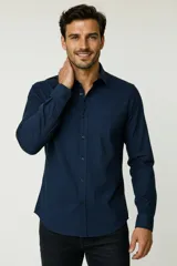 Camisa blanca de algodón, de diseño holgado y manga larga, con cuello camisero y cierre frontal de botones.