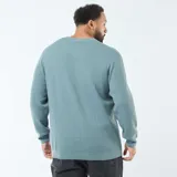 Sweater de punto gofrado, color azul verdoso, de manga larga y cuello redondo.