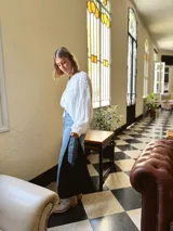 Bolso tipo tote bag negro de cuero, con costuras a la vista y manijas cortas.