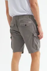 Bermuda cargo color gris oscuro, confeccionada en gabardina con efecto teñido. Presenta pretina elástica con cordón de ajuste, bolsillos laterales y bolsillos cargo con solapa en las piernas.