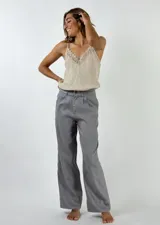 Pantalón gris de lino con corte palazzo, tiro alto y pinzas en la cintura.