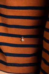 Polera de manga larga, corte ajustado al cuerpo, con cuello alto. Presenta un estampado de rayas horizontales en tonos marrón camel y azul marino.