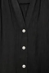 Camisa de cuello solapa y escote pico, color verde militar, con manga corta con trabilla y botón, y cierre frontal con botones.