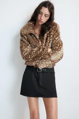 Cazadora de Zara con efecto pelo, diseño de cuello solapa y manga larga. Presenta un estampado animal print tipo cervatillo, bolsillos delanteros y cierre frontal con ganchos metálicos.