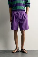 Pantalones cortos de Zara Athleticz confeccionados en tejido técnico ligero color violeta, con cintura elástica ajustable con cordón y pliegues frontales.