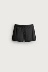 Short de baño negro de tejido técnico con estructura ripstop resistente a desgarros, cintura ajustable con cordón y bolsillos laterales.