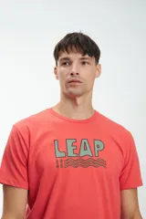 Remera de manga corta color coral con estampado en el pecho con la palabra "LEAP" en verde y un diseño de olas.